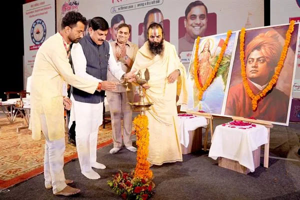 मंच पर दीप प्रज्वलित करते मुख्यमंत्री डॉ. मोहन यादव और संत, पास में स्वामी विवेकानंद सहित दो चित्र रखे हैं